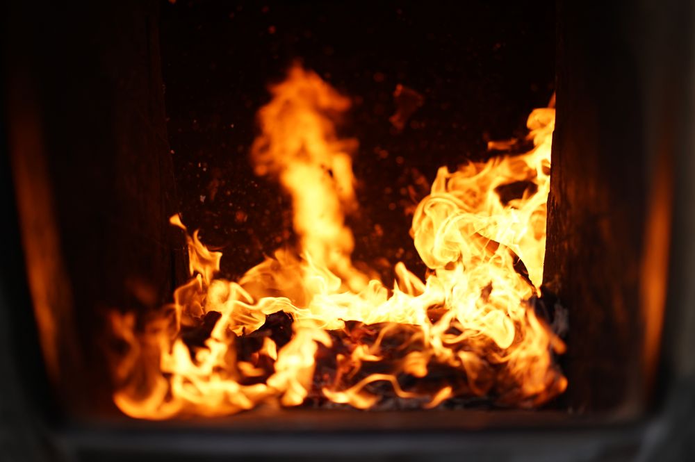 Close-up of bright orange flames inside a furnace firebox