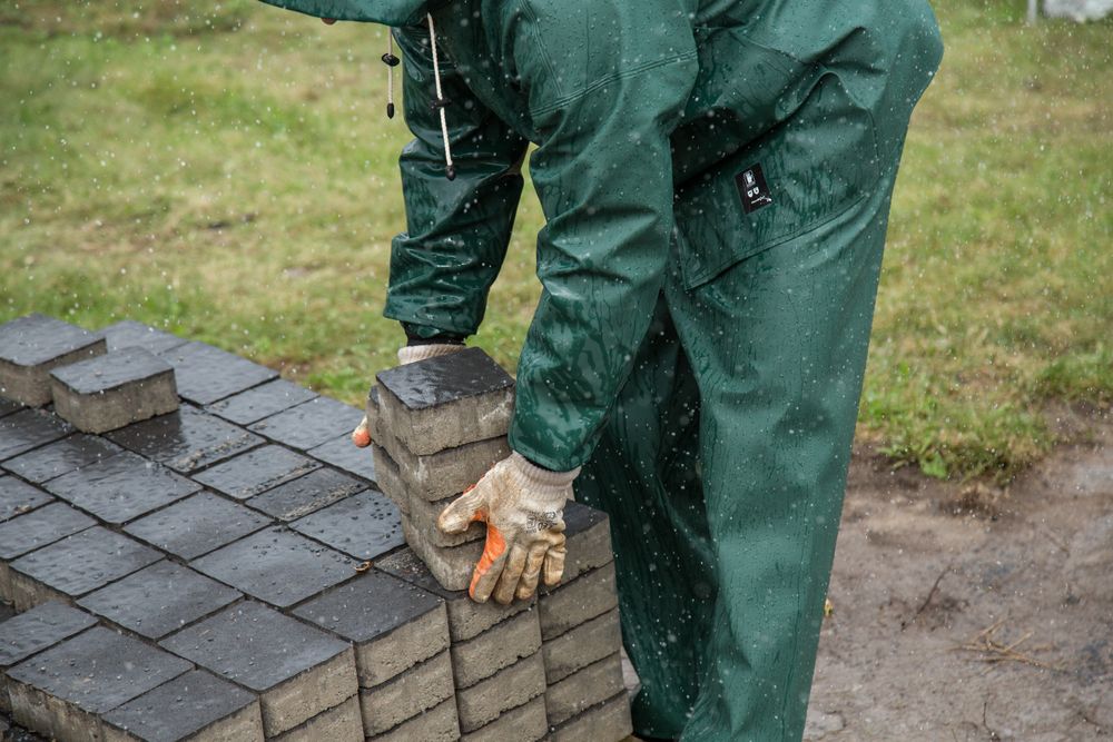 Installer setting interlocking paving stones for a new patio