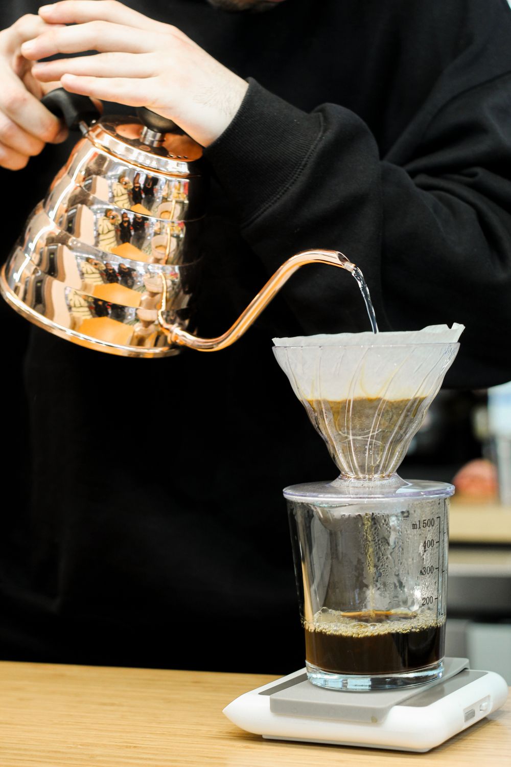 Pouring water from a copper gooseneck kettle over a pour-over filter