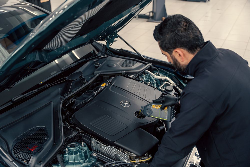 Technician servicing a European vehicle engine bay