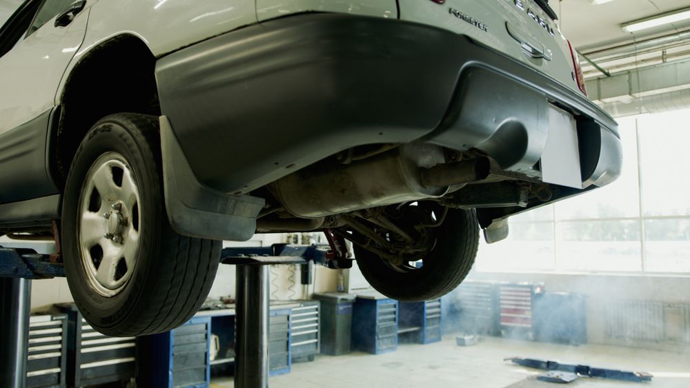 Technician performing an underlift diagnostic inspection on a vehicle